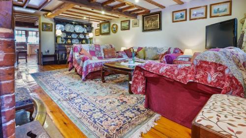 a living room with couches and a tv at Keepers Cottage in Wool
