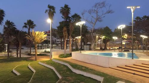 a park with a swimming pool at night at Habitación a media cuadra de la playa. in Mazatlán