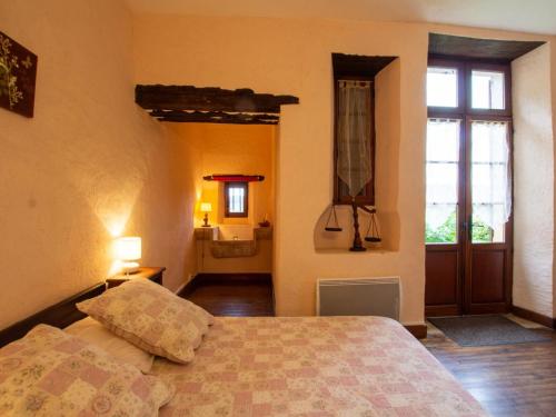 a bedroom with a bed and a window and a bathroom at Maison de village avec jardin, près de Villefranche du Périgord, idéale familles, animaux acceptés - FR-1-616-162 in Loubejac