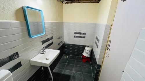 un bagno con lavandino e specchio di Greenstone Resort Hampi a Hampi