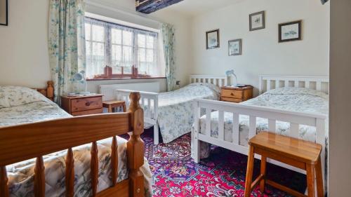 ein Schlafzimmer mit zwei Betten und einem Fenster in der Unterkunft Keepers Cottage in Wool