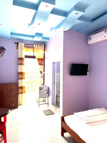 1 dormitorio con paredes moradas y techo azul en Khách Sạn Như Ý, en Ấp Tân Phú (1)