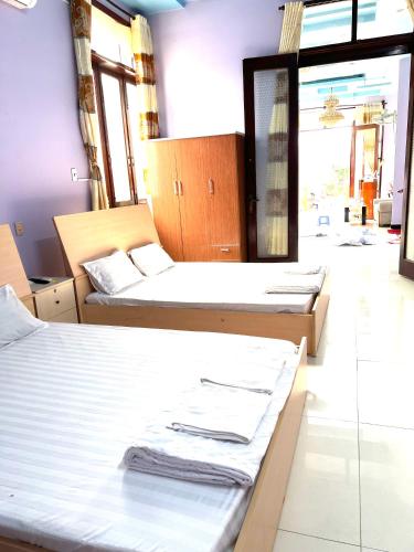 a room with three beds and a mirror at Khách Sạn Như Ý in Ấp Tân Phú (1)