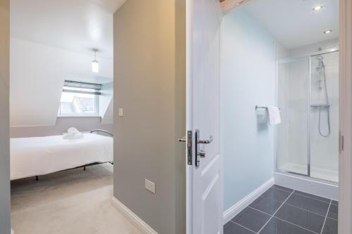 a bathroom with a walk in shower and a sink at Modern and Comfy 3 bed Cambridge House in Cambridge