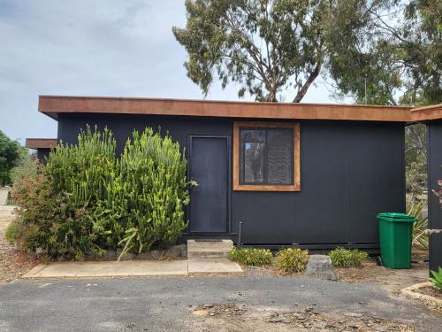 a black house with a window and a door at Backpacker, Worktime Accommodation at C & C in Stawell