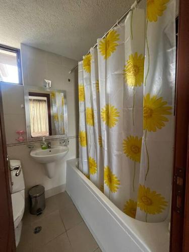 baño con cortina de ducha con flores amarillas en 1 bedroom apartment in Bay View Villas resort, en Kosharitsa