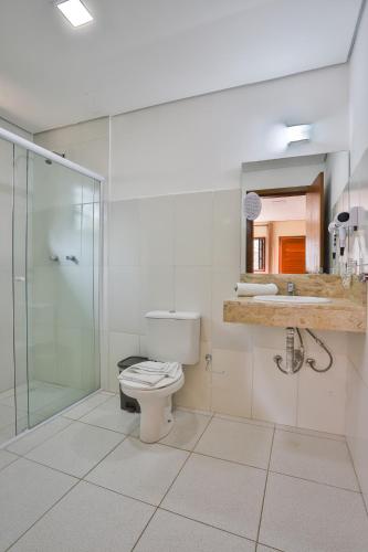 a bathroom with a toilet and a glass shower at Villaggio di Roma in Campos do Jordão