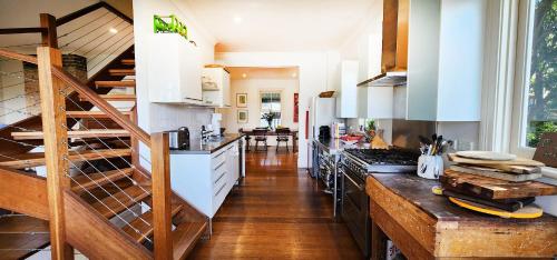 una cucina con armadietti bianchi e pavimenti in legno di Charming Balmain Home with Sydney Skyline Views a Sydney
