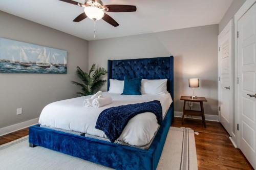 a blue bed in a bedroom with a ceiling fan at New Nashville Condo with 2 King beds walk to bars in Nashville