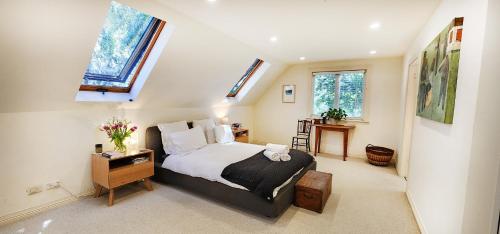 una camera con un letto e due finestre di Charming Balmain Home with Sydney Skyline Views a Sydney