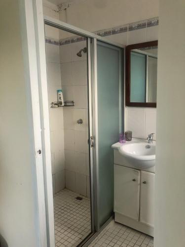 a bathroom with a shower and a sink at CC airport rooms in Nadi