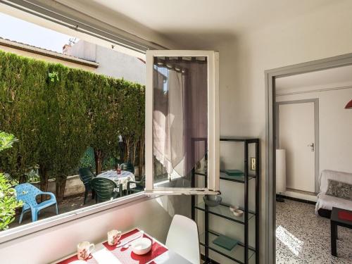 un salon avec une fenêtre, une table et des chaises dans l'établissement Studio 3 pers avec terrasse près de la plage et des commerces - FR-1-776-80, à Saint-Cyprien
