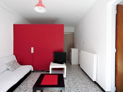 - un salon avec un mur rouge et un canapé dans l'établissement Studio 3 pers avec terrasse près de la plage et des commerces - FR-1-776-80, à Saint-Cyprien