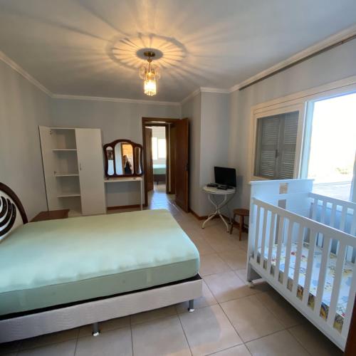 a bedroom with a bed and a crib at Pousada Villa Koller in Marcelino Ramos