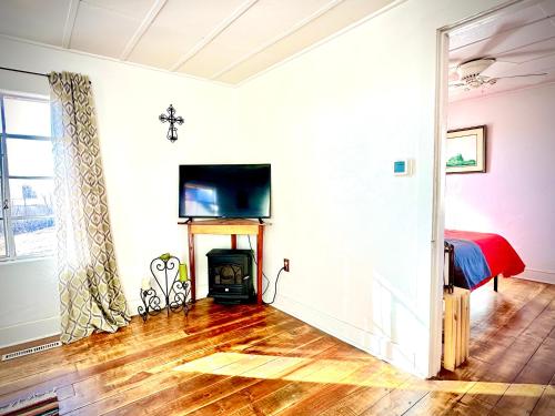 a room with a fireplace and a bed and a television at The Casita in Raton