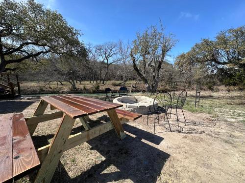a picnic table and a fire pit in a field at Bandera Stronghold - Cochise Tipi in Bandera