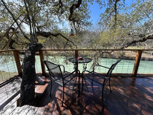 a table and chairs on a deck with a tree at Bandera Stronghold - Cochise Tipi in Bandera