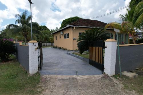 ein Haus mit einem Tor und einer Einfahrt in der Unterkunft Elizabeth Retreat - Island time in Ocho Rios