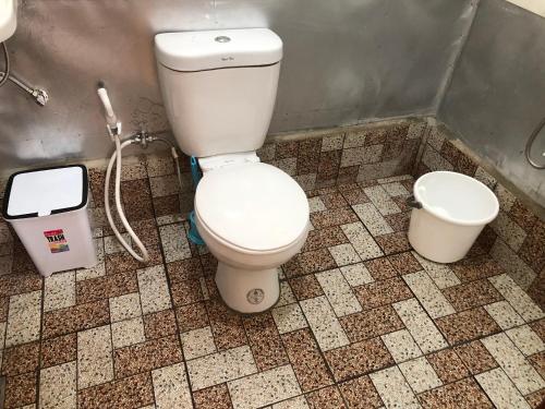łazienka z białą toaletą w kabinie w obiekcie MIOKI HOMETEL w mieście Batuan
