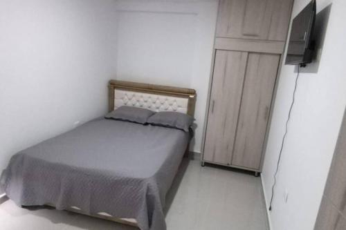 - une petite chambre avec un lit et une télévision dans l'établissement Apartamento Amueblados Jireh, à San Onofre