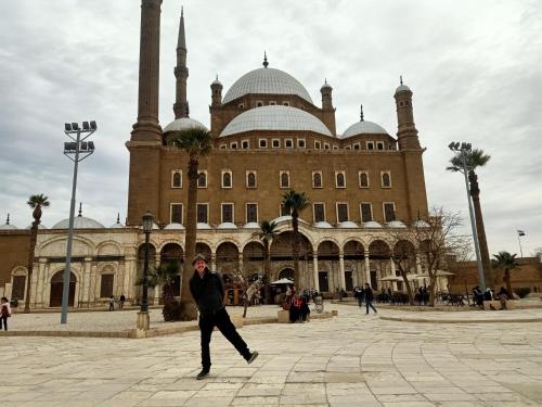 a man is walking in front of a building at Eyad Pyramids view in Cairo