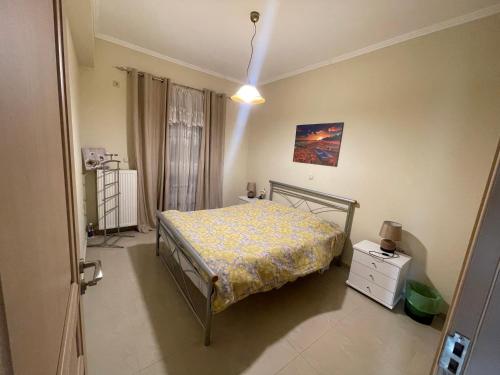 um quarto com uma cama com uma colcha amarela em Cozy apartment Kokkoni beach em Kokkónion