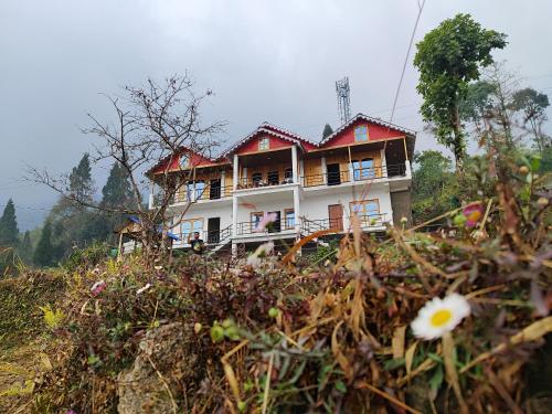 a house on the side of a hill with flowers at Mount View Homestay Sittong in Mangpu