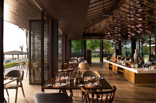 クイニョンにあるAnantara Quy Nhon Villasのテーブルと椅子とバーのあるレストラン