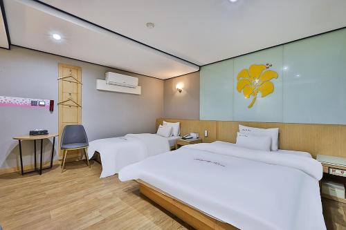 a bedroom with two beds and a table and a chair at Flower Hotel in Seoul