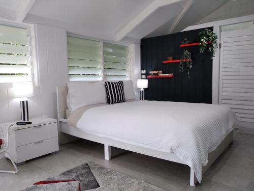 um quarto com uma cama branca e uma parede preta em Eumundi Yacht Club B&B em Eumundi