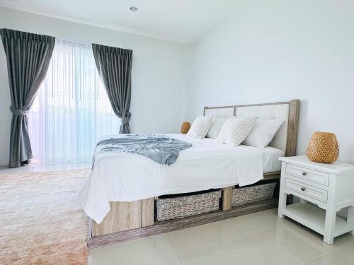 a white bedroom with a large bed and a white table at White Castle in Panwa Beach