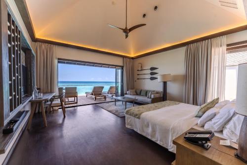 a bedroom with a bed and a view of the ocean at Veligandu Maldives Resort Island in Rasdhoo