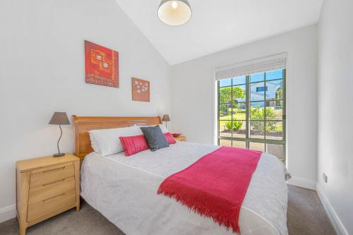 a bedroom with a large bed and a window at Lighthouse Beach Luxury in Port Macquarie