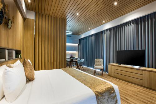 a bedroom with a bed and a flat screen tv at Kinaralana Hotel Yogyakarta in Yogyakarta