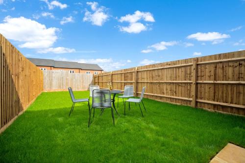 a patio with a table and chairs on the grass at Contractors & Families Delight - Spacious 3-Bed Accommodation Sleeps 7, Snooker Table, Smart TV, Netflix, Parking, Derby City Centre in Derby