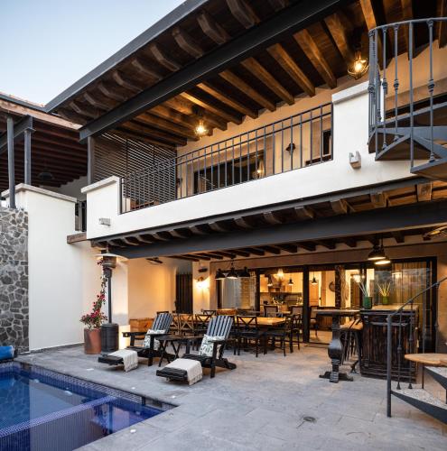 an outdoor patio with a pool and tables and chairs at Private Jacuzzi & Pool, Elegant La Escondida 5BR in San Miguel de Allende
