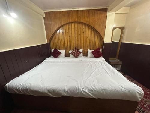 a large bed with a wooden headboard in a room at Salix in Darjeeling