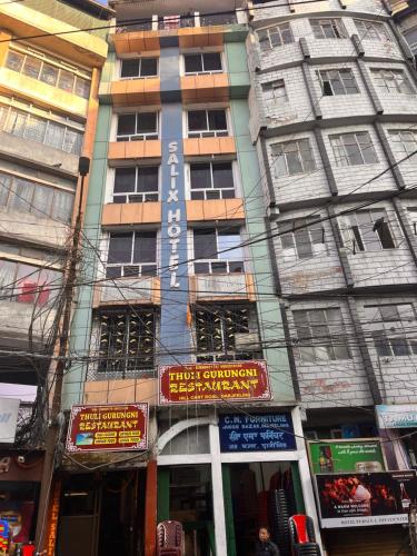 a tall building with signs on the side of it at Salix in Darjeeling
