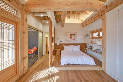 um quarto com uma cama num quarto com tectos em madeira em Hongsi Art House em Gongju