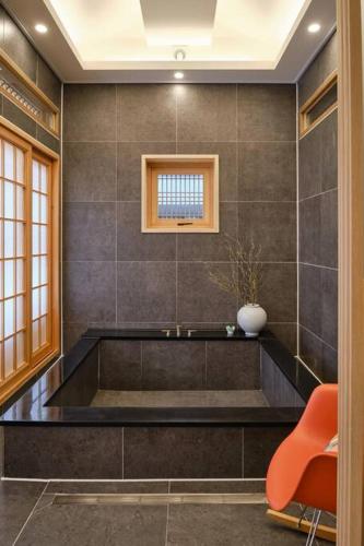 a bathroom with a large tub with a vase on it at Hongsi Art House in Gongju