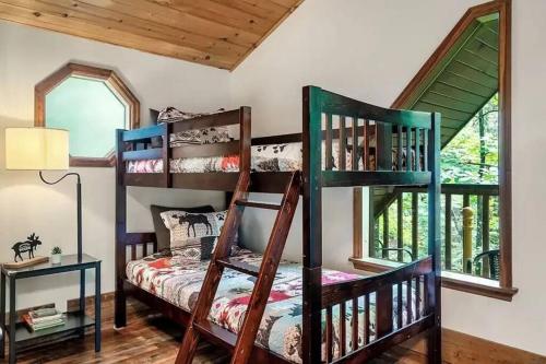 a room with two bunk beds and a window at Beary Peaceful Smokies Retreat: Hot-Tub & Pools in Pigeon Forge