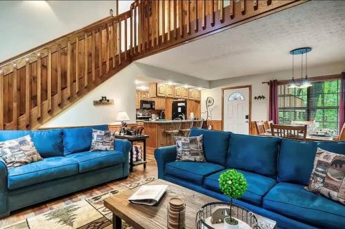 a living room with a blue couch and a table at Cozy Cabin, Sleeps 8 - Close to Dollywood with Hot Tub, Arcade, Community Pool in Pigeon Forge