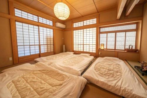 a large bed in a room with windows at Rokuan in Kikugawa