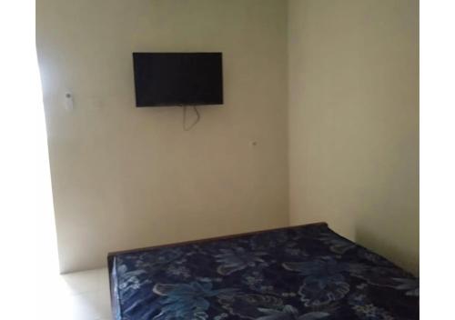 una camera con letto e TV a schermo piatto di GUEST HOUSE LUCKY a Padayungan