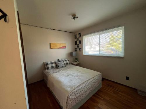 a small bedroom with a bed and a window at Cozy Double Room with a Garden and a Patio in Delta