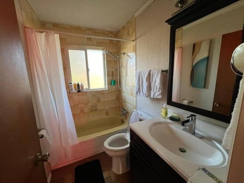 a bathroom with a sink and a toilet and a tub at Cozy Double Room with a Garden and a Patio in Delta