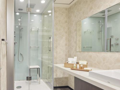 La salle de bains est pourvue d'une douche en verre et d'un lavabo. dans l'établissement Gion Shinmonso, à Kyoto