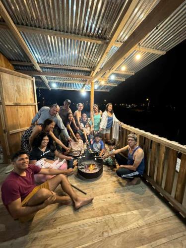 um grupo de pessoas sentadas à volta de uma fogueira no convés em House Beach em Puerto Cayo