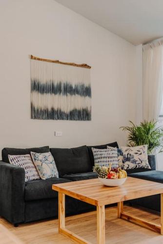 a living room with a black couch and a wooden coffee table at SeaSalt BeachFront Holiday Home, Private pool, 2 Bedroom house in Chaloklum