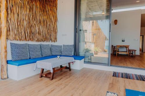 a living room with a blue couch and a table at SeaSalt BeachFront Holiday Home, Private pool, 2 Bedroom house in Chaloklum